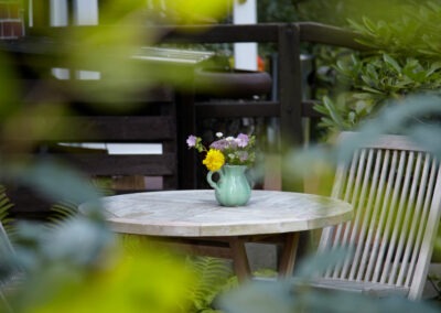 Sitzgruppe vorm Appartement mit Blumenvase